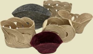 A range of handwoven raffia bag samples in natural, grey and burgundy